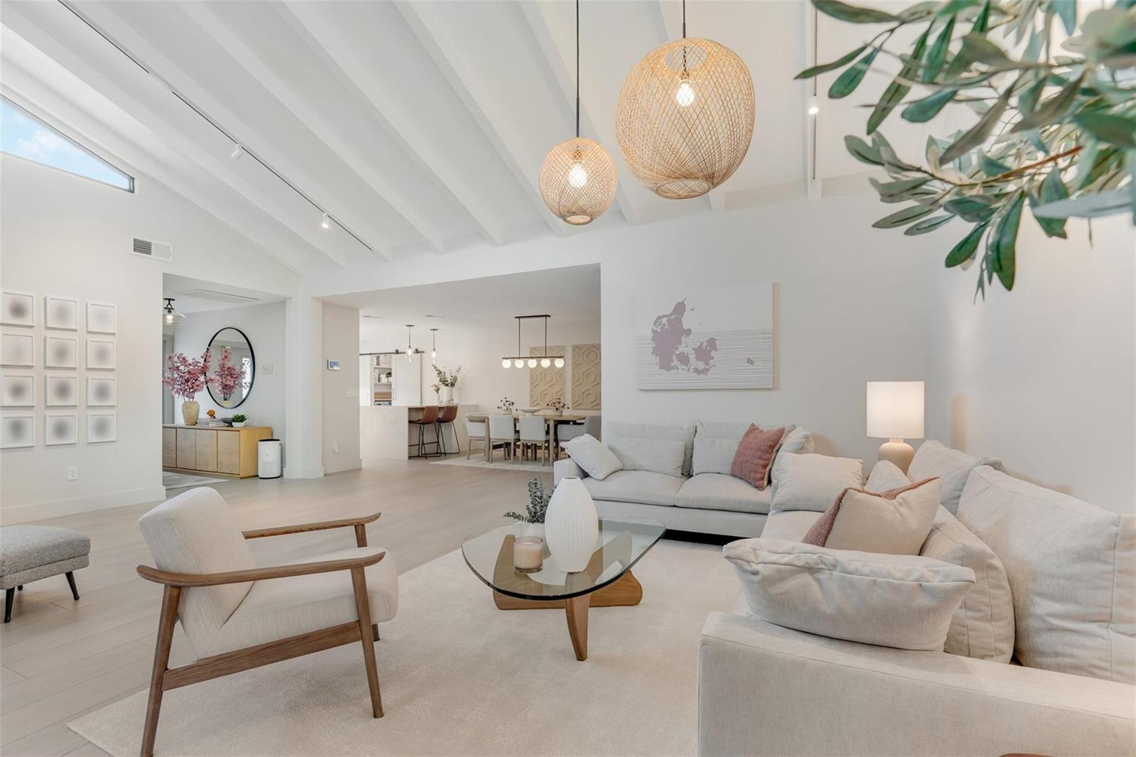 A bright, open-concept living room features vaulted ceilings, neutral furnishings, and a glass coffee table — 8569 Casa Del Lago, Boca Raton FL 33433, BOCA RATON, FL