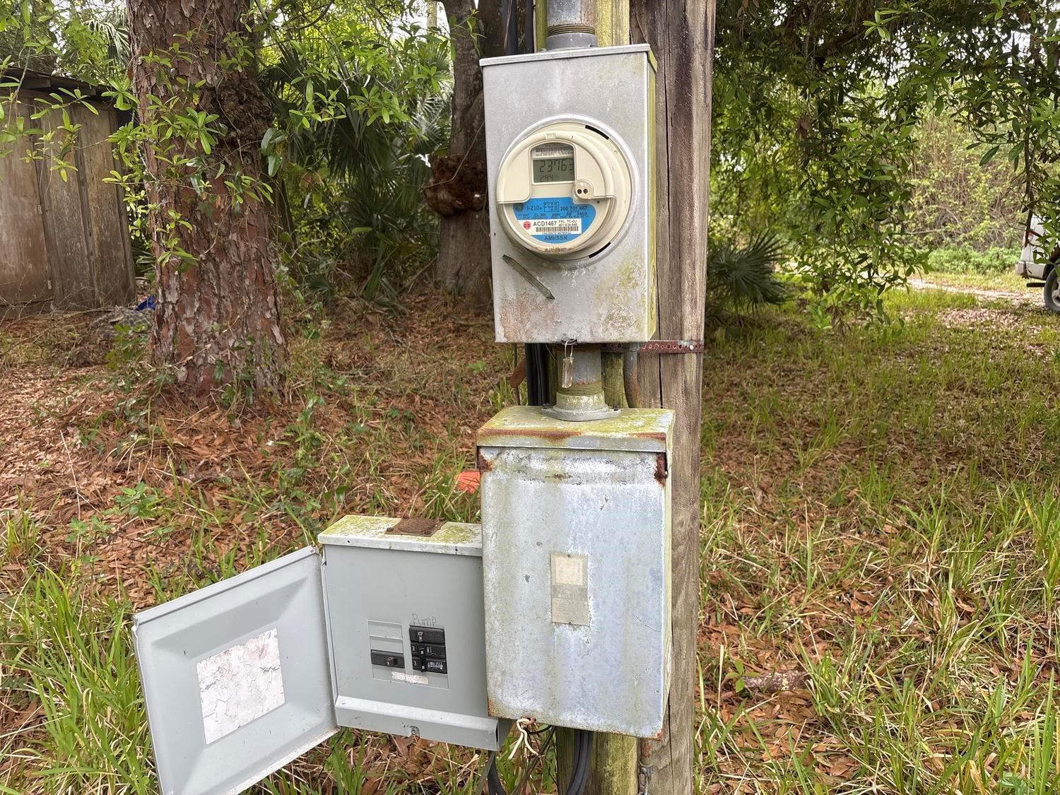 An outdoor utility pole features an electric meter mounted above a metal breaker box — 6015 State Road 710, Okeechobee FL 34974, OKEECHOBEE, FL