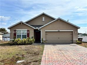 A single-story house with a tan stucco exterior, a two-car garage, and a brick driveway — 3815 SW 11th Pl, Cape Coral FL 33914, CAPE CORAL, FL