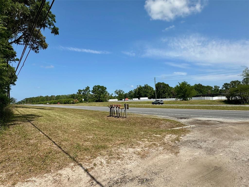 A grassy roadside area features a cluster of mailboxes next to a paved highway — 12100 NW US HIGHWAY 441, GAINESVILLE, FL