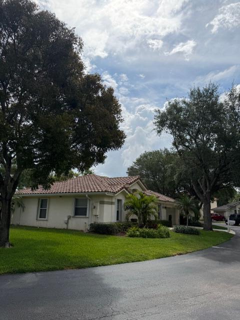 A single-story house with a tiled roof and lawn is surrounded by large trees — 3415 Dunes Vista Drive, Pompano Beach FL 33069, POMPANO BEACH, FL