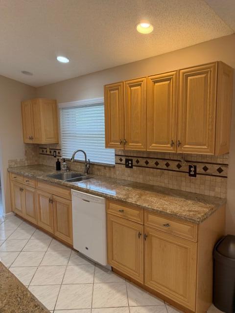 A kitchen features light wood cabinets, granite countertops, a white dishwasher, and tiled flooring — 3415 Dunes Vista Drive, Pompano Beach FL 33069, POMPANO BEACH, FL