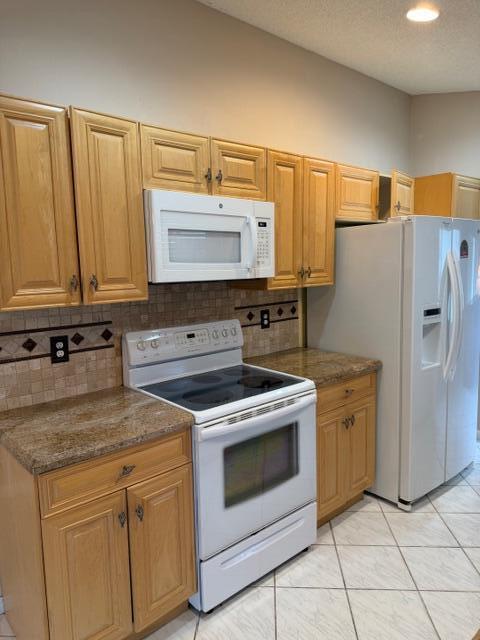 A kitchen features light wood cabinets, granite countertops, a white stove, and a white refrigerator — 3415 Dunes Vista Drive, Pompano Beach FL 33069, POMPANO BEACH, FL