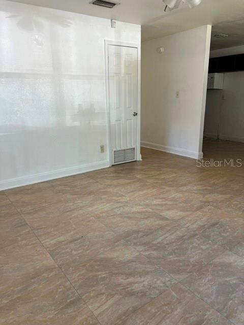 A room with light-colored walls, a white interior door, and brown tile flooring — 1227 SE 19TH TERRACE, GAINESVILLE, FL