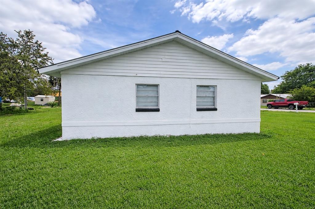 A white, single-story house exterior with two windows and a gabled roof — 1004 BOOKER AVENUE, SEBRING, FL
