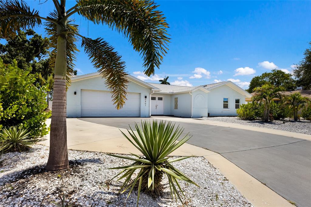 A light blue single-story house features a two-car garage and a paved driveway — 5407 2ND AVENUE DRIVE NW, BRADENTON, FL