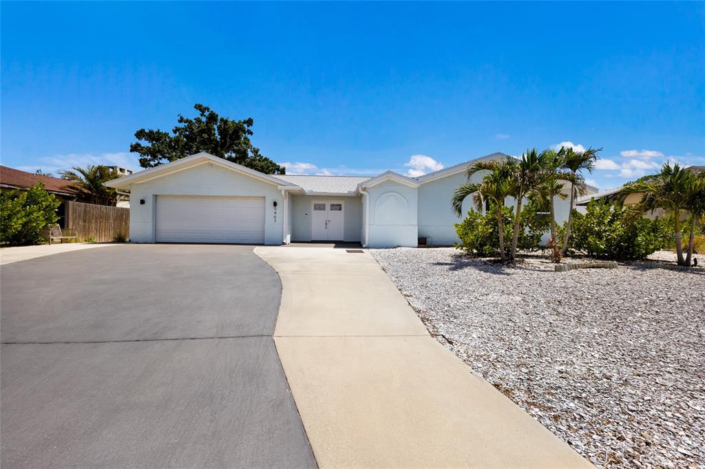 A light blue single-story house features a two-car garage and a paved driveway — 5407 2ND AVENUE DRIVE NW, BRADENTON, FL