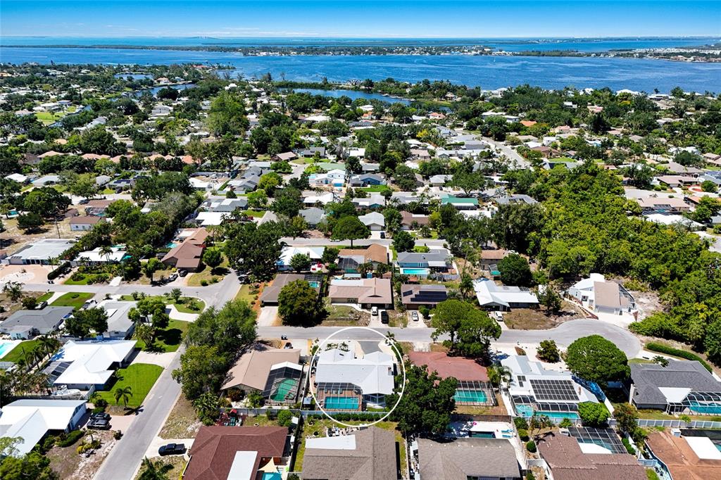 An aerial view shows a residential neighborhood with a circled house featuring a swimming pool — 5407 2ND AVENUE DRIVE NW, BRADENTON, FL