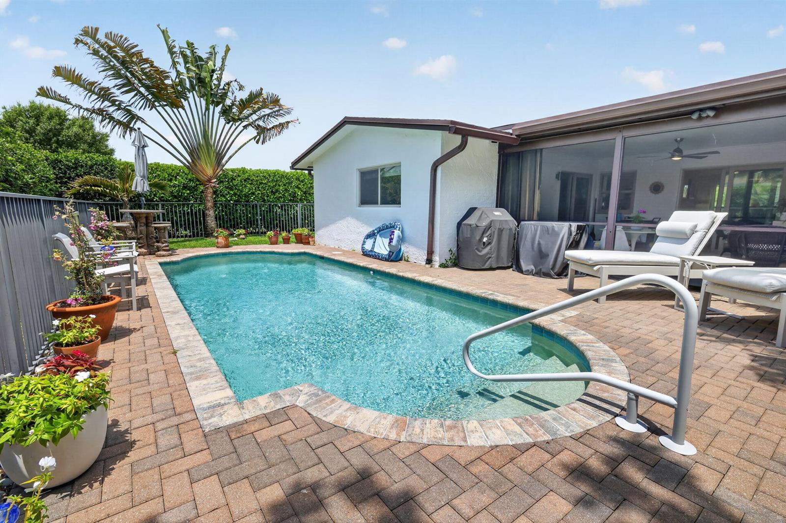 A backyard features a rectangular swimming pool with a brick paver deck and patio furniture — 6372 Sleepy Willow Way, Delray Beach FL 33484, DELRAY BEACH, FL
