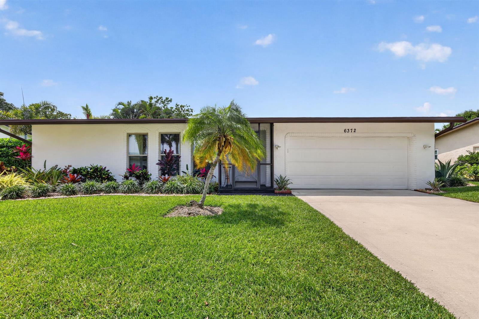 A single-story house with a white exterior, a two-car garage, and a front lawn — 6372 Sleepy Willow Way, Delray Beach FL 33484, DELRAY BEACH, FL