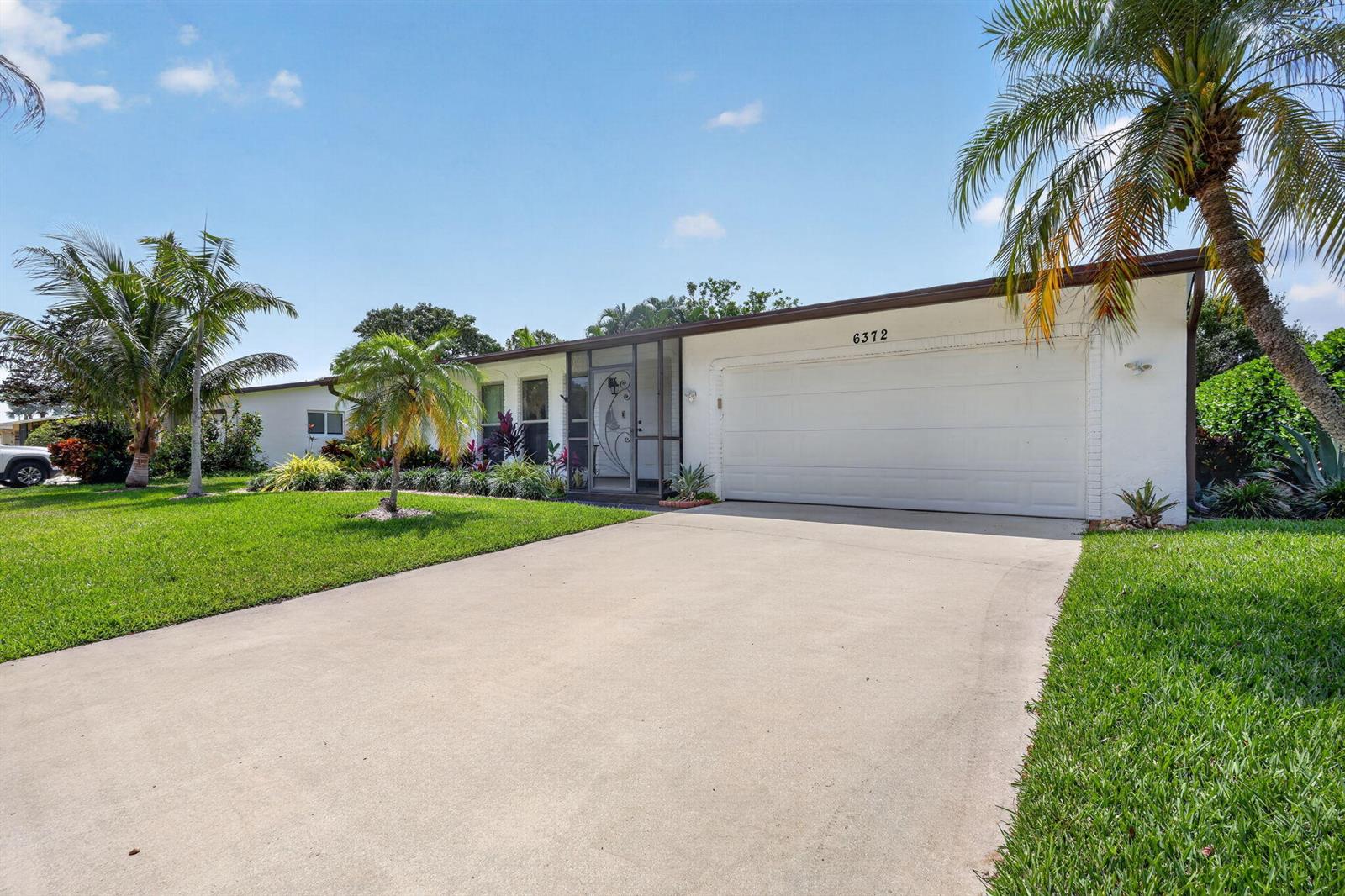 A white single-story house with a two-car garage and a screened front entryway — 6372 Sleepy Willow Way, Delray Beach FL 33484, DELRAY BEACH, FL