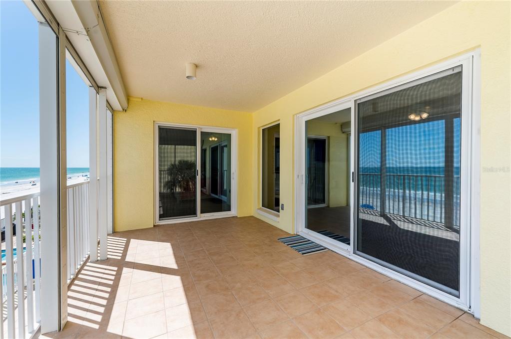 A tiled balcony features sliding glass doors and a white railing overlooking the ocean — 16750 GULF BOULEVARD UNIT 311, NORTH REDINGTON BEACH, FL