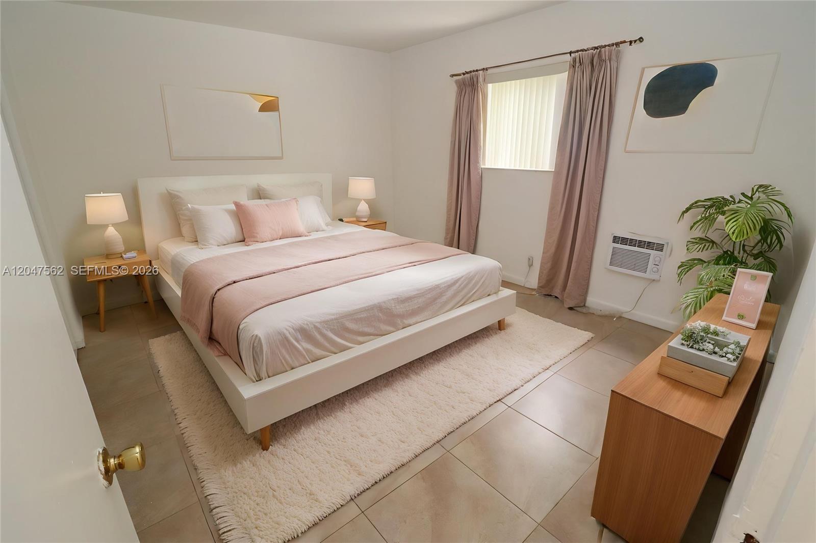 A bedroom features a white bed with pink bedding, tiled floors, and a window — 1708 N 16th Ave # 2, Hollywood FL 33020, HOLLYWOOD, FL