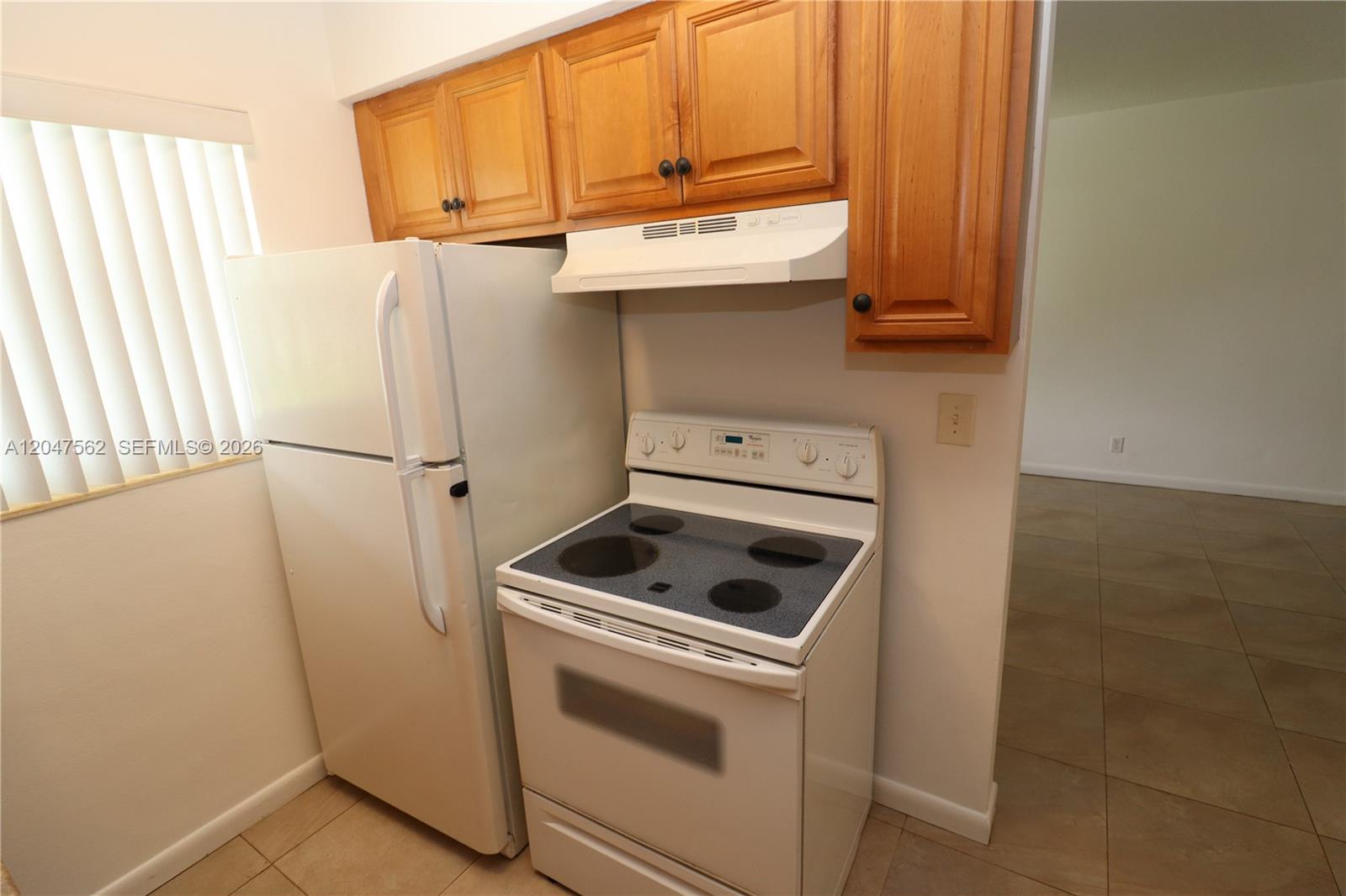 A kitchen features a white refrigerator, a white electric stove, and wood-toned upper cabinets — 1708 N 16th Ave # 2, Hollywood FL 33020, HOLLYWOOD, FL