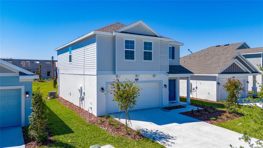 A two-story house with a white stucco facade, gray siding, and a two-car garage — 5858 LE MARIN WAY, KISSIMMEE, FL