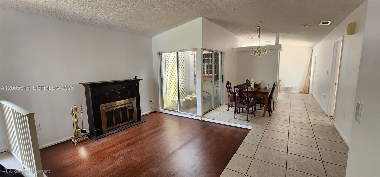 A living room with a fireplace, wood flooring, and an adjacent dining area with tile — 5335 SW 153rd Ave, Miami FL 33185, MIAMI, FL