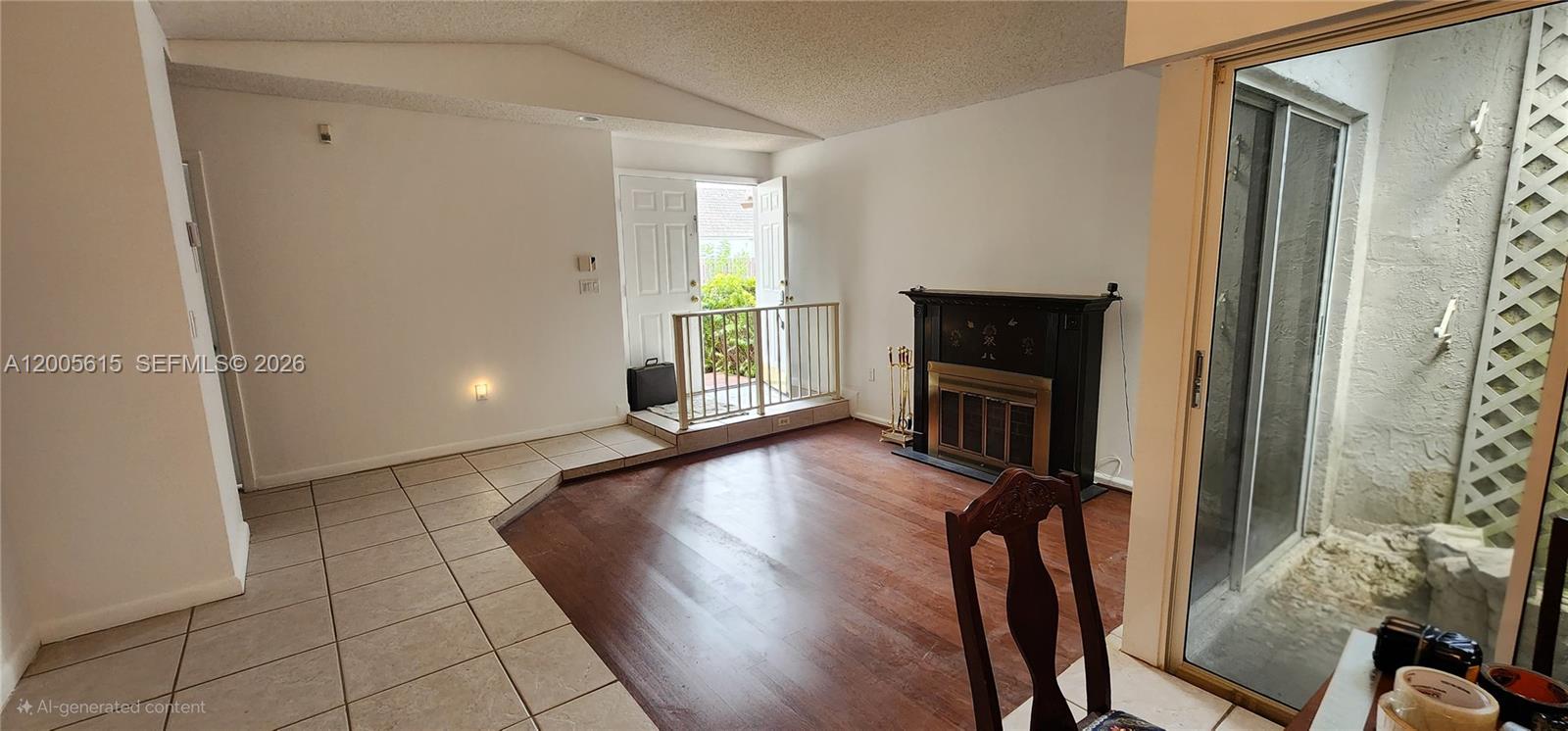 A living room features a fireplace, wood flooring, tiled entryway, and a sliding glass door — 5335 SW 153rd Ave, Miami FL 33185, MIAMI, FL