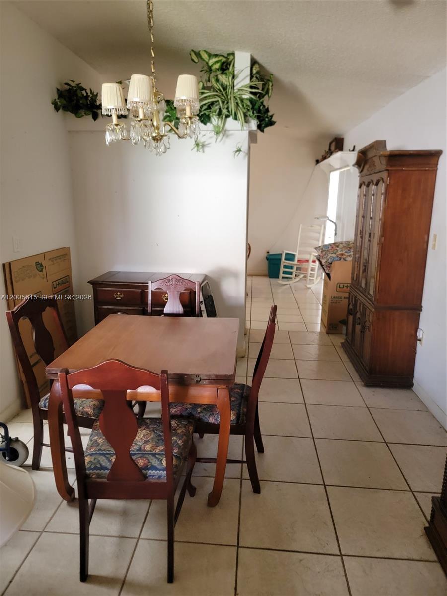 A dining area features a wooden table, chairs, a hutch, and a chandelier — 5335 SW 153rd Ave, Miami FL 33185, MIAMI, FL