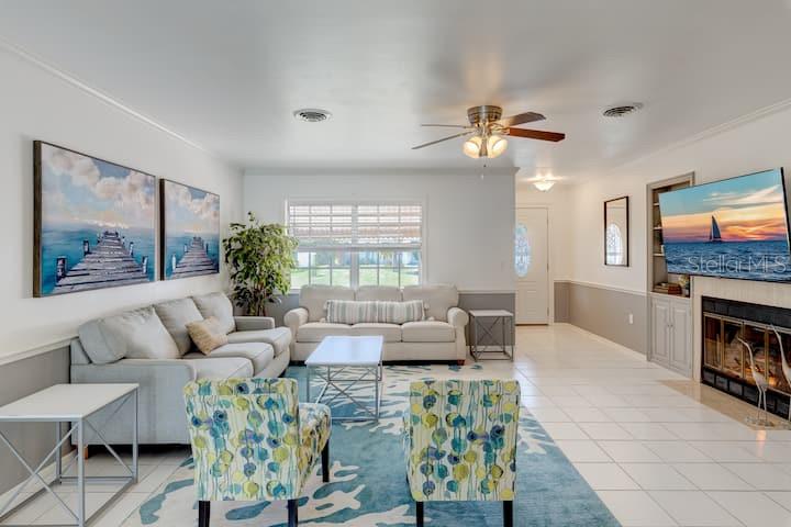 A living room features a light-colored sofa, two patterned armchairs, a fireplace, and tile flooring — 231 CADDY ROAD, ROTONDA WEST, FL