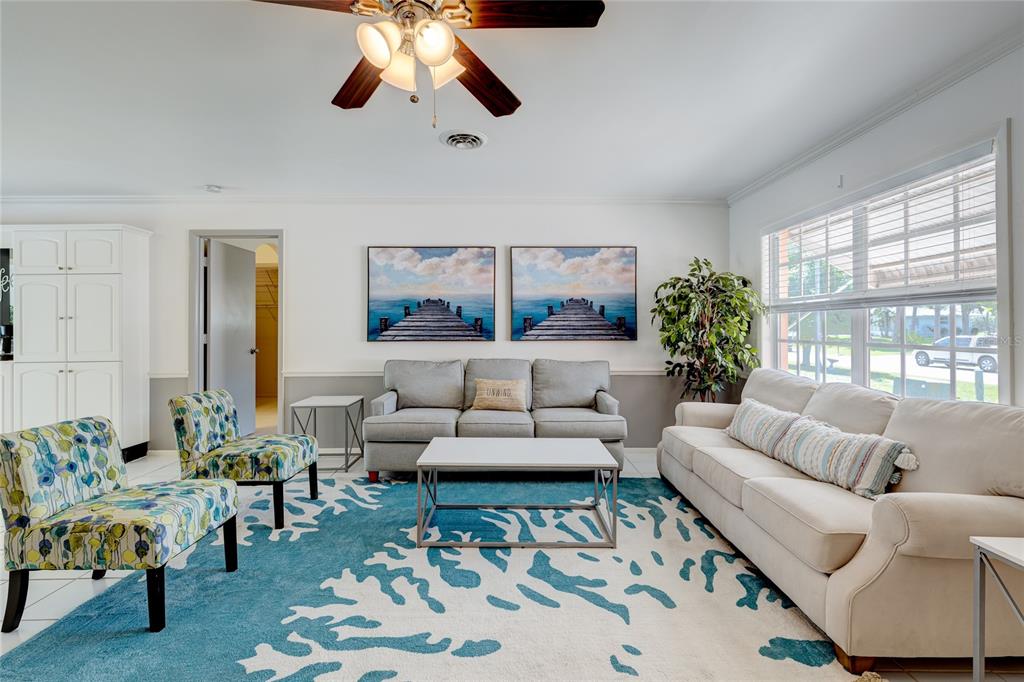 A living room features a blue and white area rug, two sofas, and two patterned chairs — 231 CADDY ROAD, ROTONDA WEST, FL