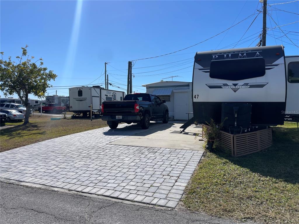 A black pickup truck is parked on a paved driveway between two travel trailers — 47 ILLINOIS STREET, PALMETTO, FL