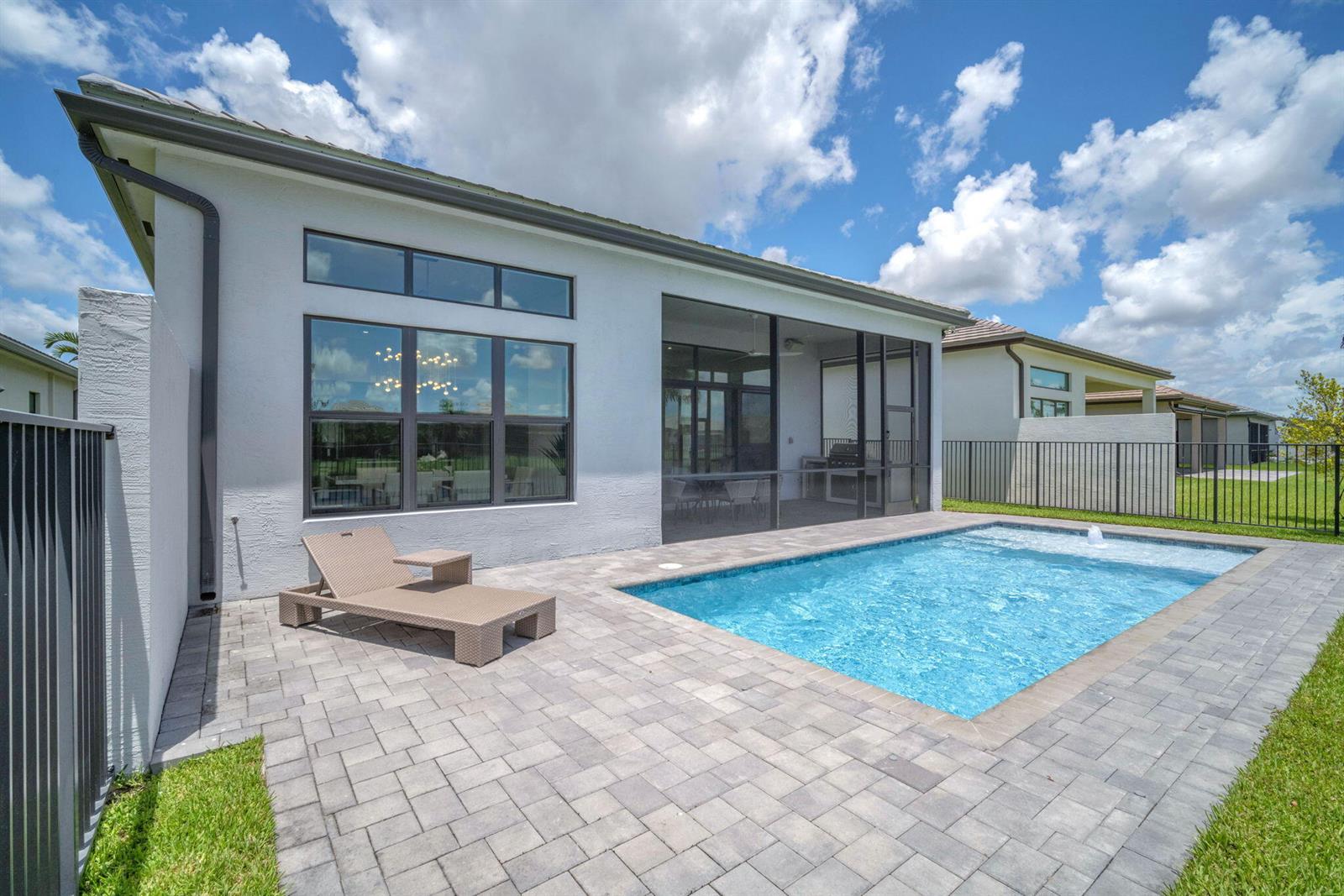 A backyard features a rectangular swimming pool, a paved patio, and a screened-in porch area — 9651 Spruce Woods Drive, Boynton Beach FL 33473, BOYNTON BEACH, FL