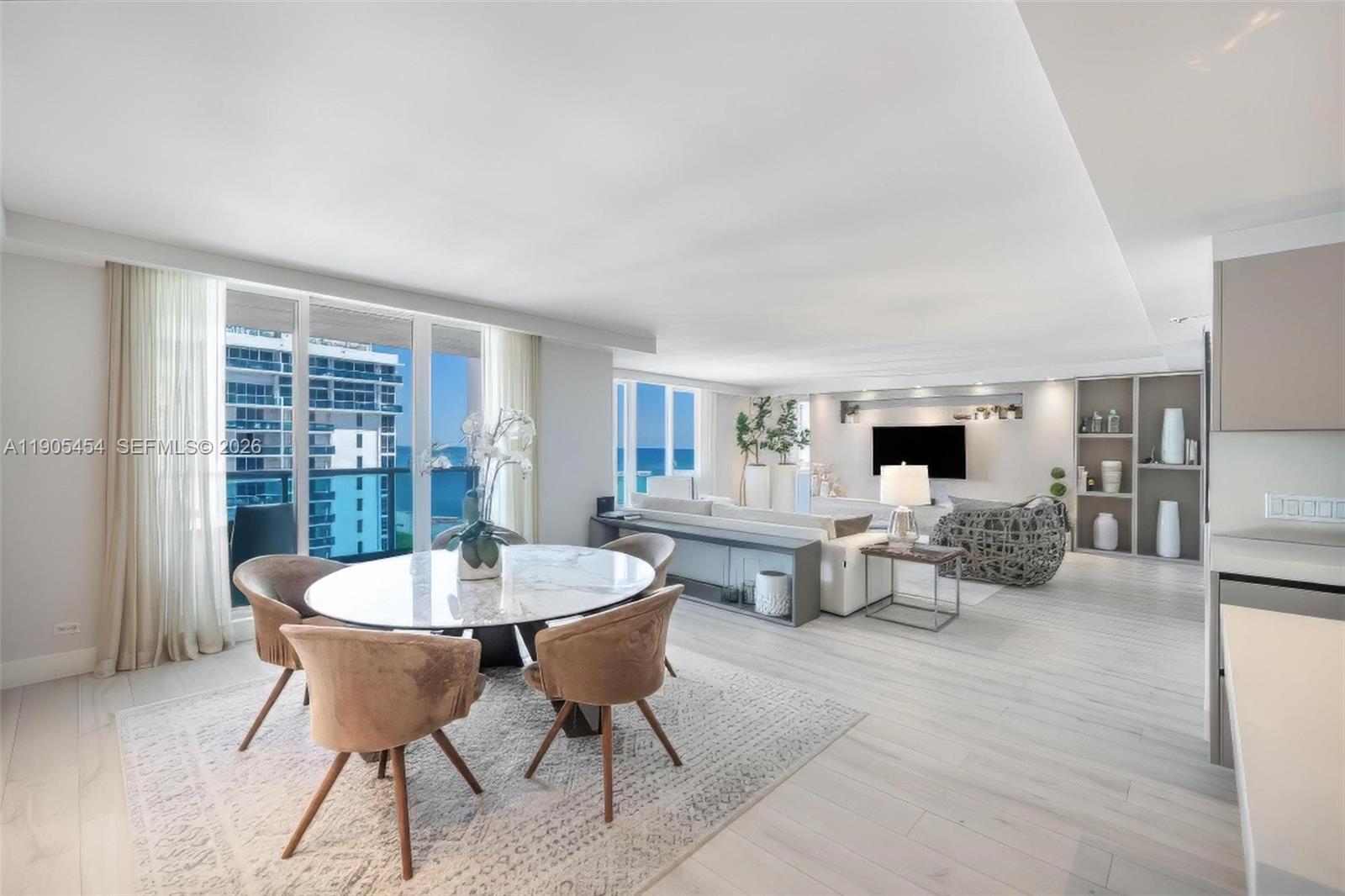 A bright, open-concept living and dining area features light wood floors and ocean views — 2301 Collins Ave, Miami Beach FL 33139, MIAMI BEACH, FL