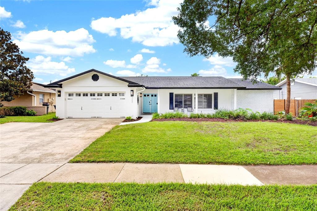 A white exterior porch features two chairs, a small table, and a turquoise front door — 722 S RANGER BOULEVARD, WINTER PARK, FL
