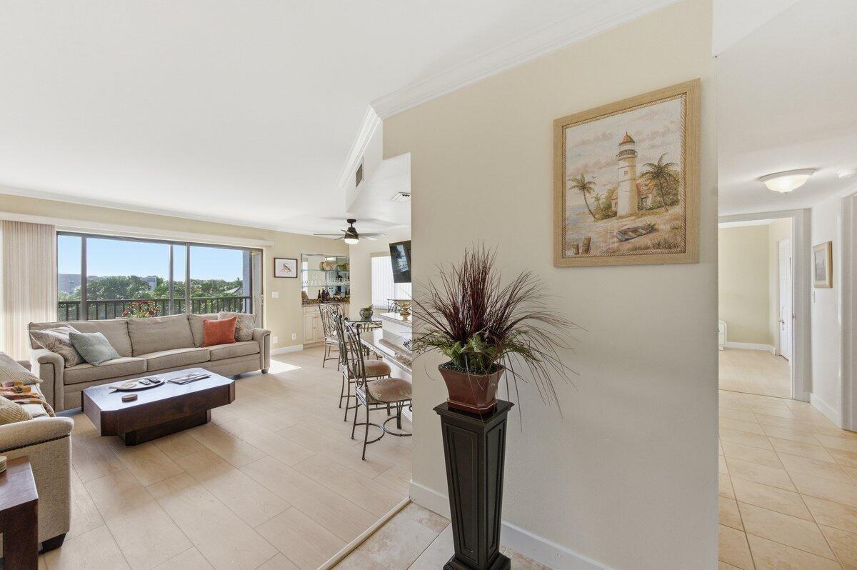A living room with a beige sofa, tile flooring, and a lighthouse painting on the wall — 1605 S Us Highway 1 # A408, Jupiter FL 33477, JUPITER, FL
