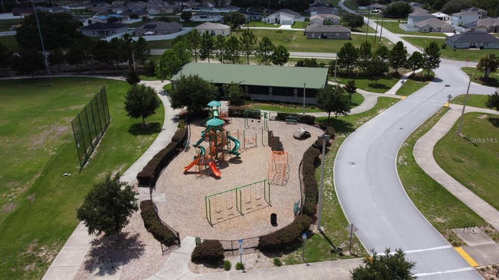 An aerial view of a neighborhood playground with a play structure, swings, and a pavilion — 562 MARICOPA DRIVE, KISSIMMEE, FL
