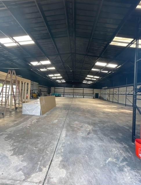 An expansive, open industrial warehouse space features a high metal ceiling and concrete flooring — 424 S DE LEON AVENUE, TITUSVILLE, FL