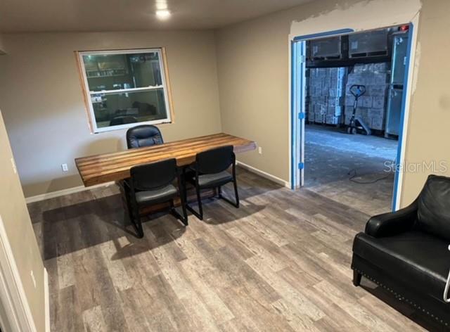 An office room features a wooden desk, two black chairs, and a doorway leading outside — 424 S DE LEON AVENUE, TITUSVILLE, FL