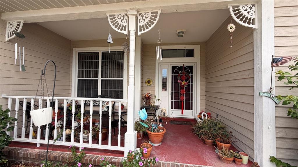 A covered front porch features a white railing, a wooden post, and potted plants — 3671 E ARBOR LAKES DRIVE, HERNANDO, FL