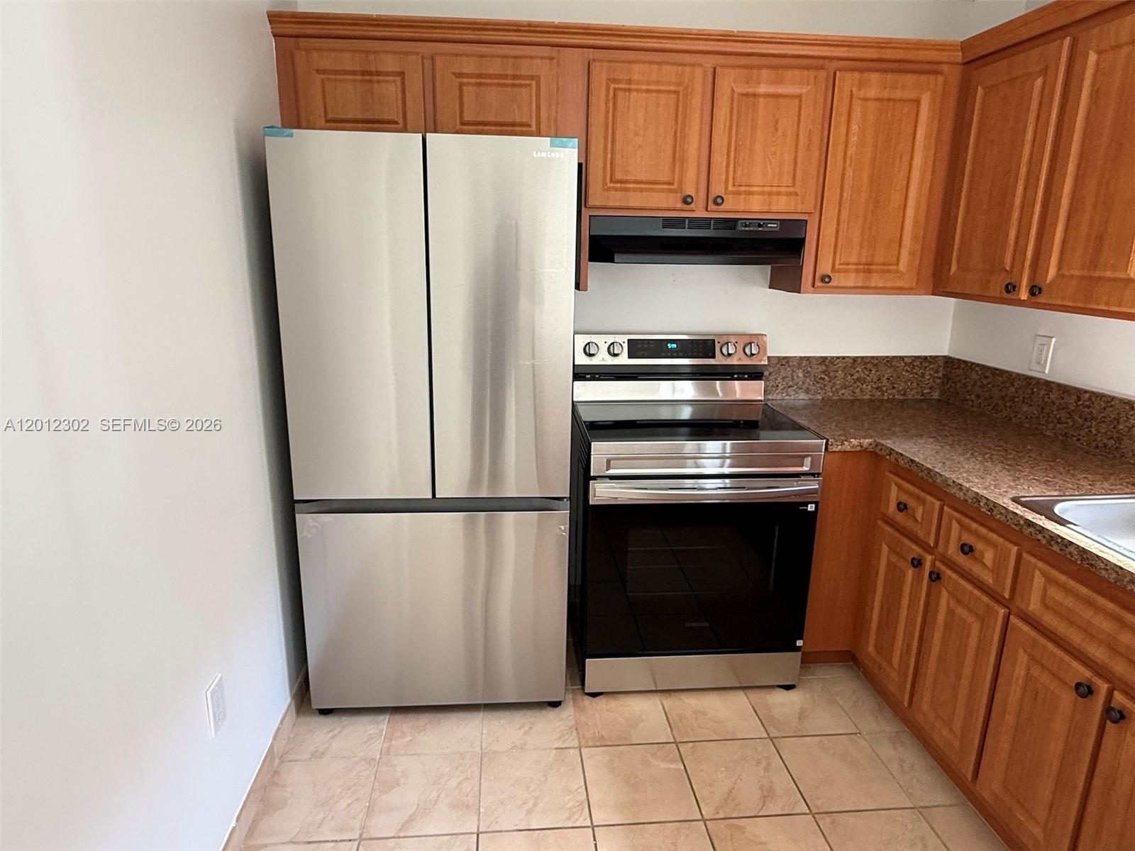 A kitchen features stainless steel appliances, wood cabinets, and brown speckled countertops — 6850 NW 173rd Dr # 109, Hialeah FL 33015, HIALEAH, FL