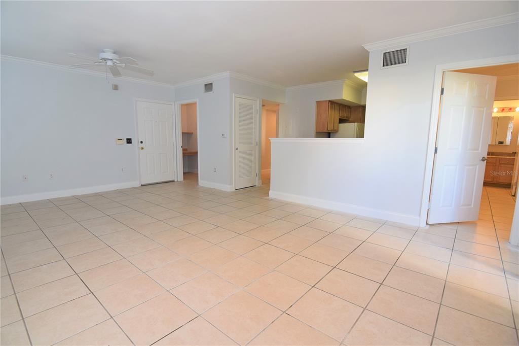 A tiled living area features a ceiling fan, a kitchen pass-through, and multiple interior doors — 1185 VILLAGIO CIRCLE UNIT 103, SARASOTA, FL
