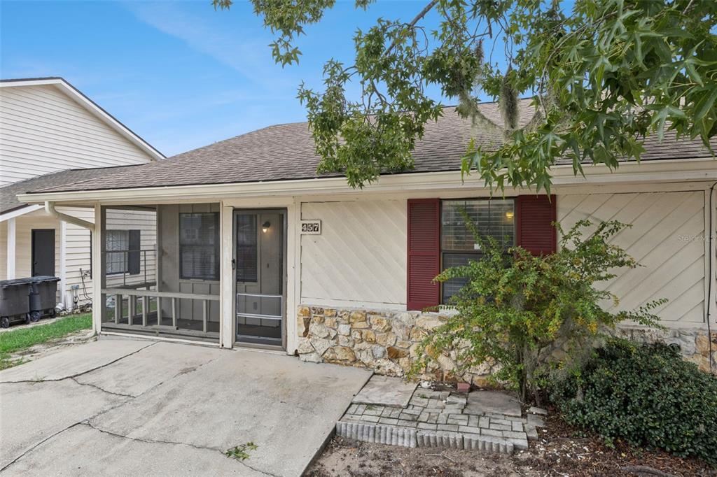 A single-story house with a screened porch, stone facade, and red shutters — 457 HEMLOCK STREET, ALTAMONTE SPRINGS, FL