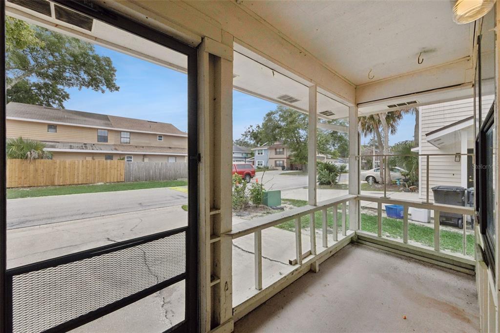 A screened-in porch with a concrete floor overlooks a residential street and neighboring houses — 457 HEMLOCK STREET, ALTAMONTE SPRINGS, FL
