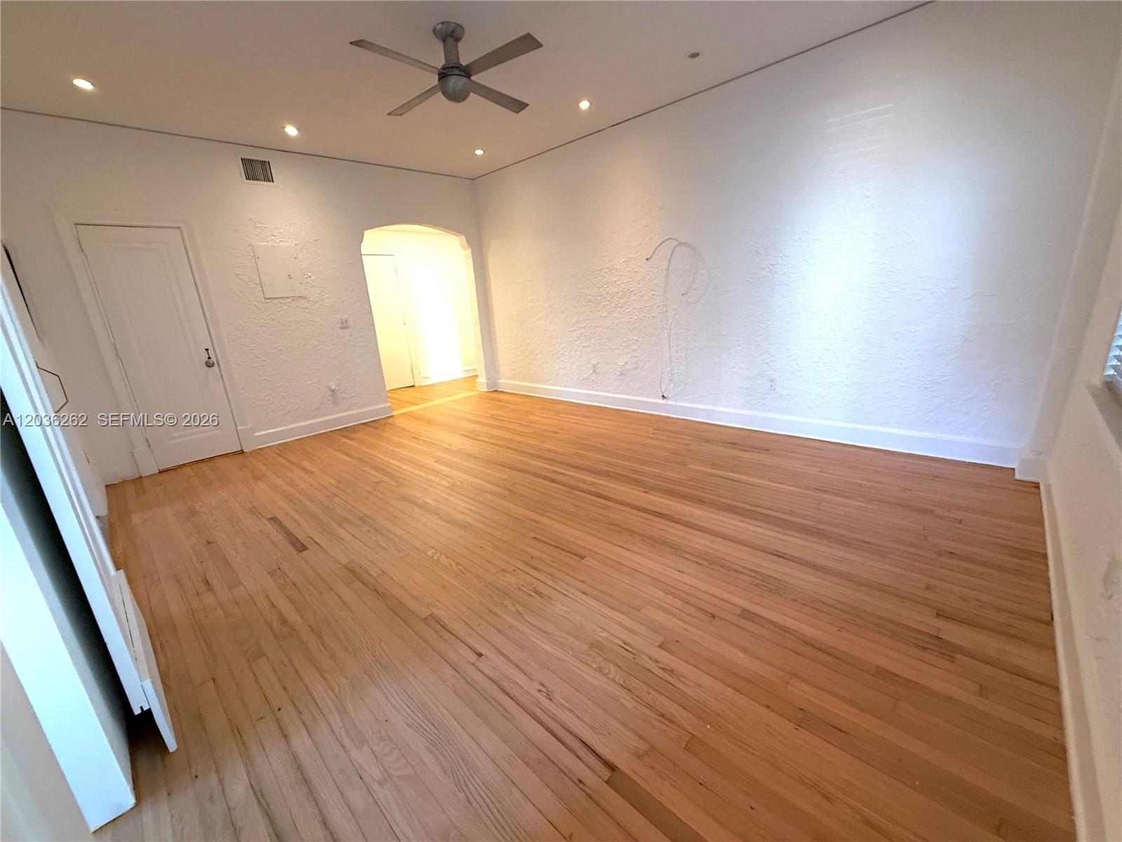 An empty room features hardwood floors, white textured walls, a ceiling fan, and recessed lighting — 900 16th St # 108, Miami Beach FL 33139, MIAMI BEACH, FL