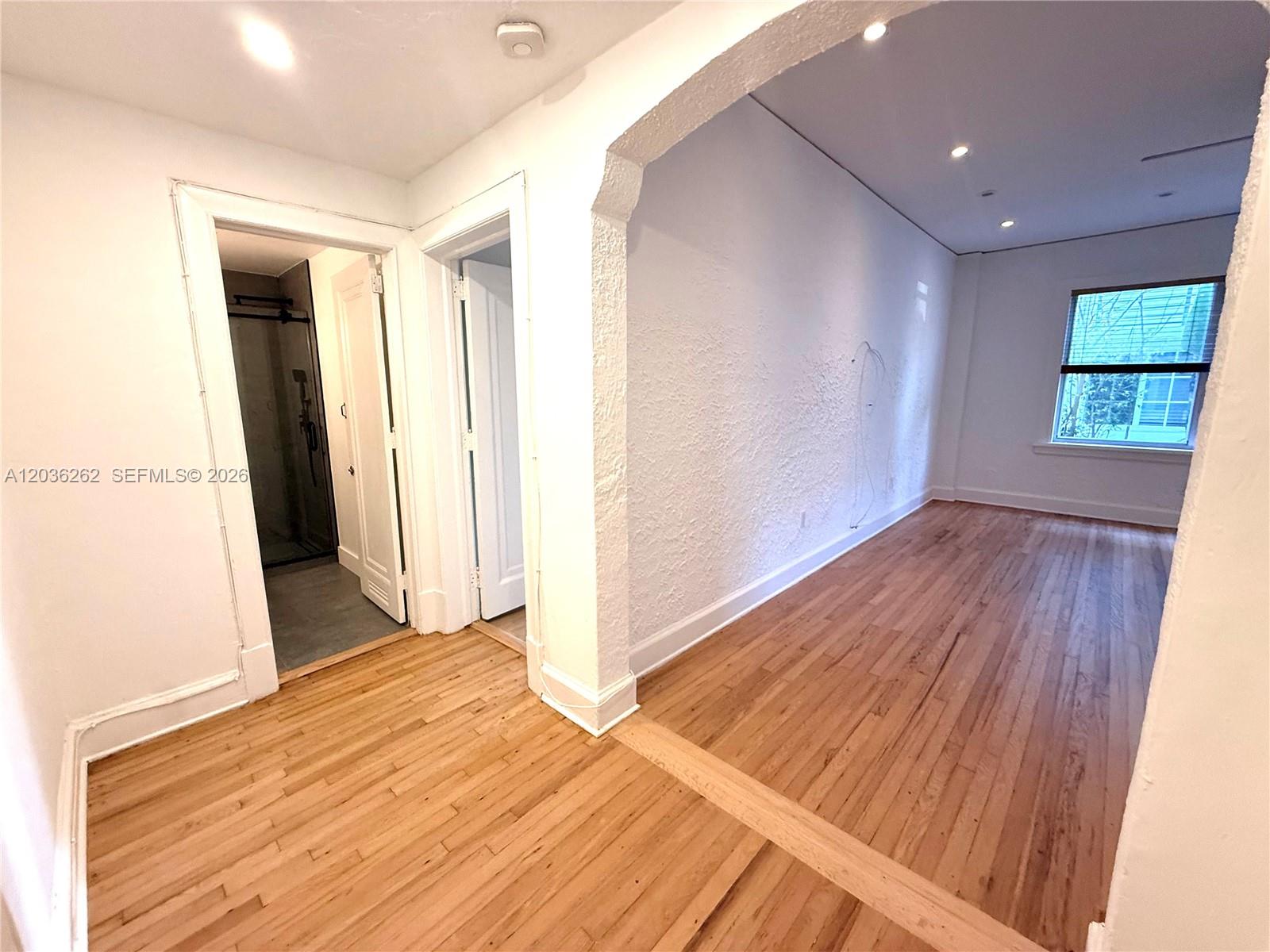 An interior view shows a room with hardwood floors, a textured wall, and two doorways — 900 16th St # 108, Miami Beach FL 33139, MIAMI BEACH, FL