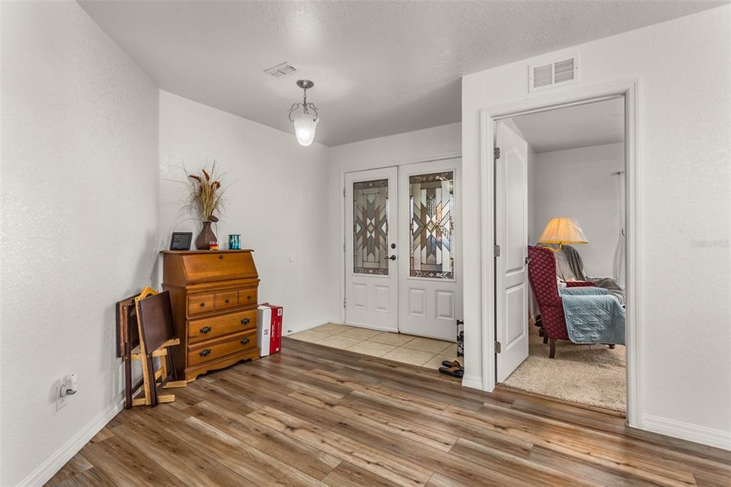 An entryway features wood-look flooring, a wooden desk, and a double door with glass inserts — 215 CAPTAIN HOOK WAY, DAVENPORT, FL