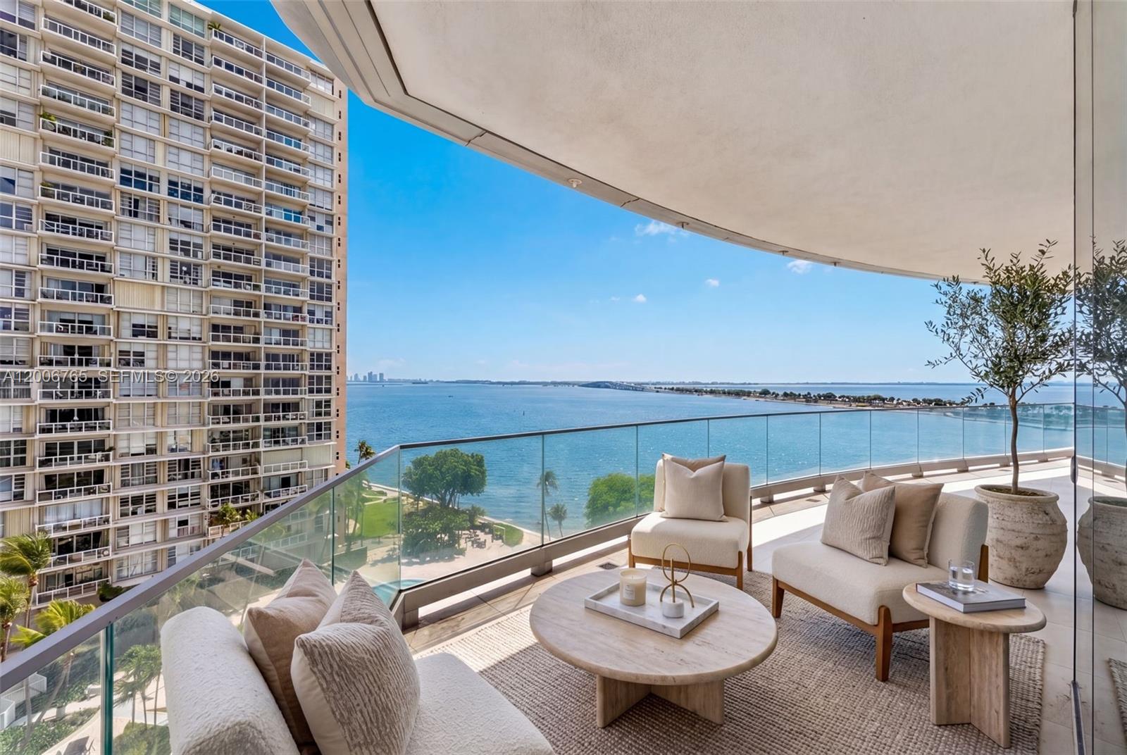 A furnished balcony overlooks the ocean and a neighboring high-rise building — 175 SE 25th Rd # 604, Miami FL 33129, MIAMI, FL