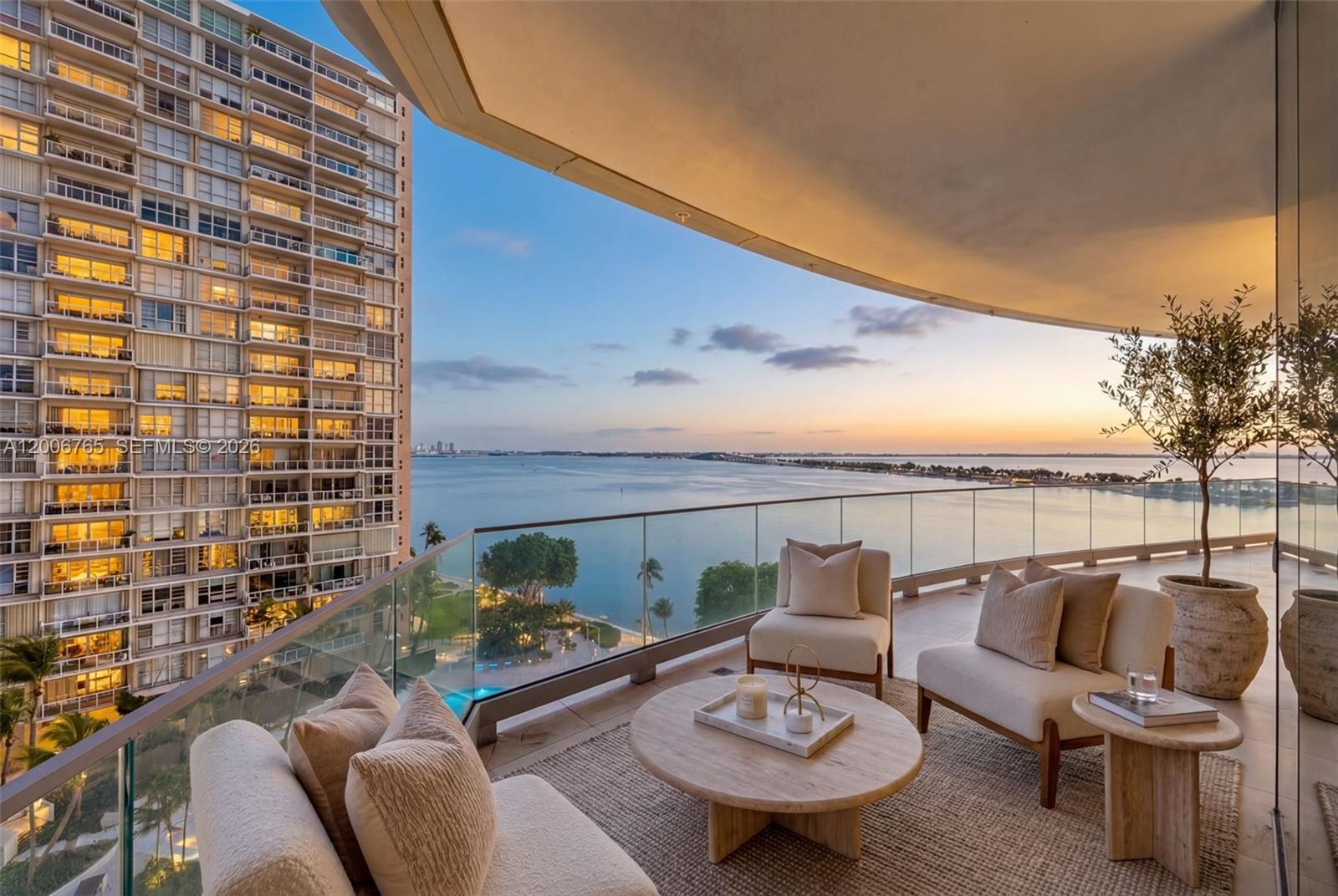 A high-rise balcony features outdoor seating, a round coffee table, and panoramic water views — 175 SE 25th Rd # 604, Miami FL 33129, MIAMI, FL