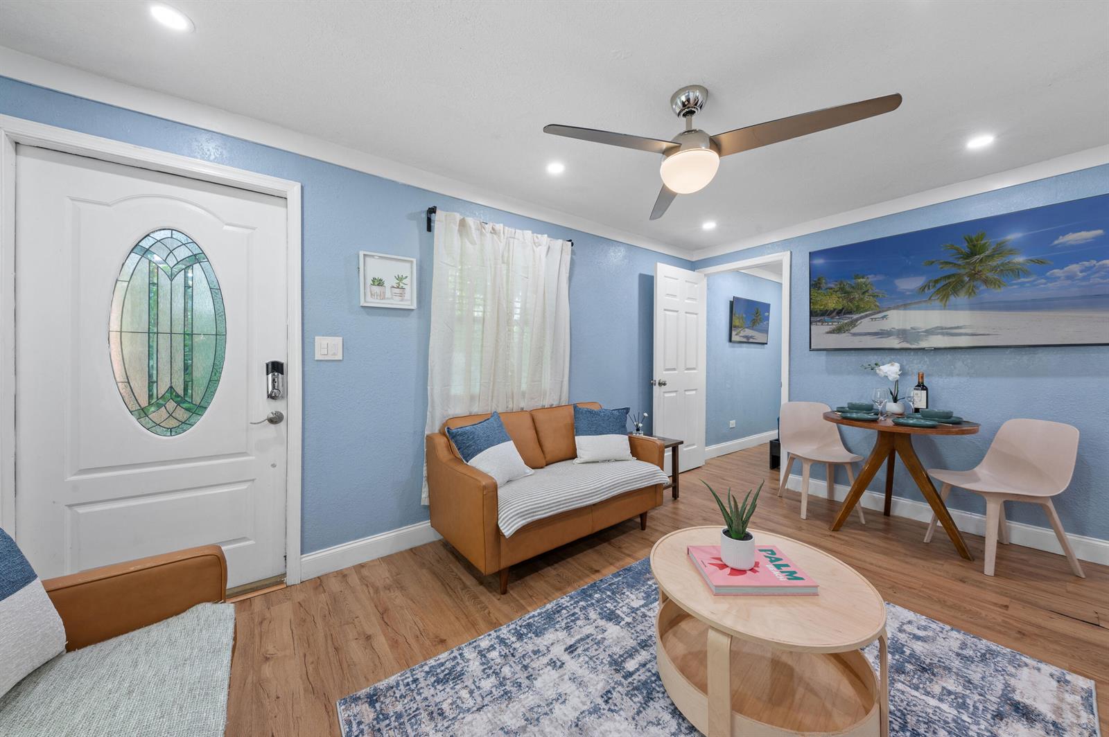 A living room features light blue walls, a brown sofa, a dining set, and wood flooring — 420 Avenida Alegre # 3, West Palm Beach FL 33405, WEST PALM BEACH, FL