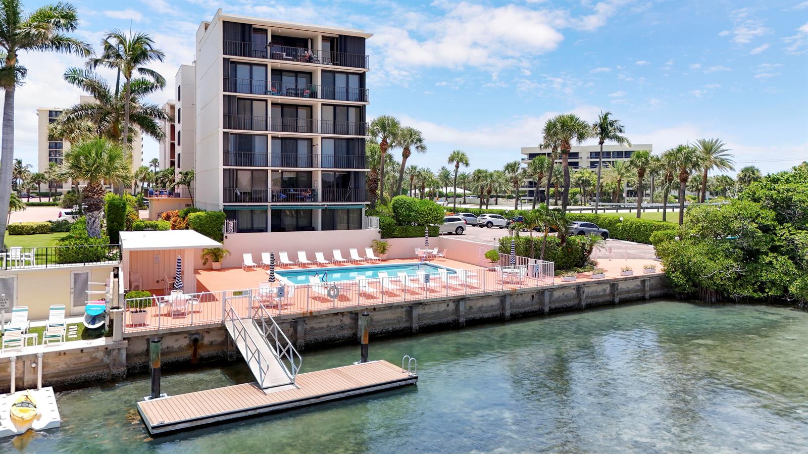 An aerial view shows a multi-story apartment building with a pool deck and boat dock — 225 S Beach Road # 605, Jupiter FL 33469, JUPITER, FL