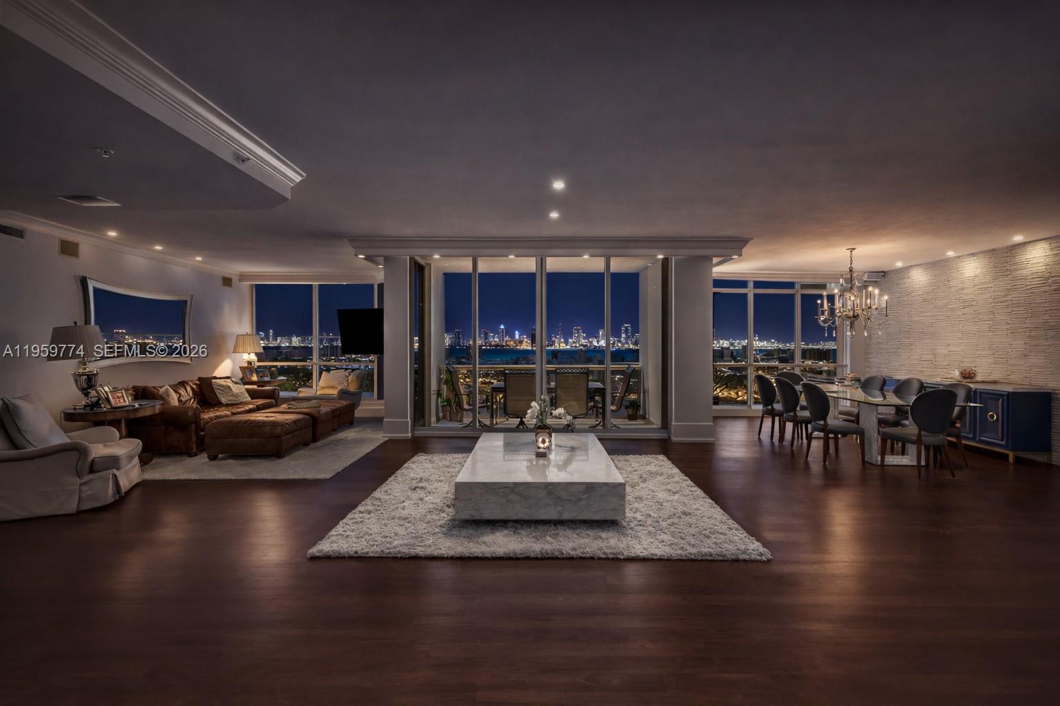 A spacious living and dining area features dark wood floors, floor-to-ceiling windows, and city views — 1900 Sunset Harbour Dr, Miami Beach FL 33139, MIAMI BEACH, FL