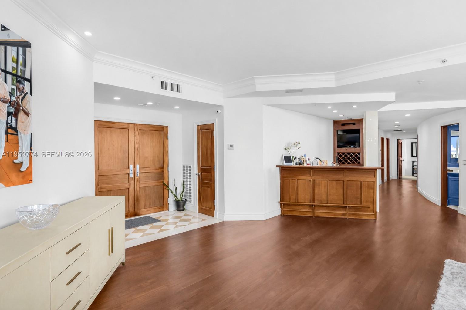 A spacious foyer with wood flooring leads to a built-in wooden bar area — 1900 Sunset Harbour Dr, Miami Beach FL 33139, MIAMI BEACH, FL