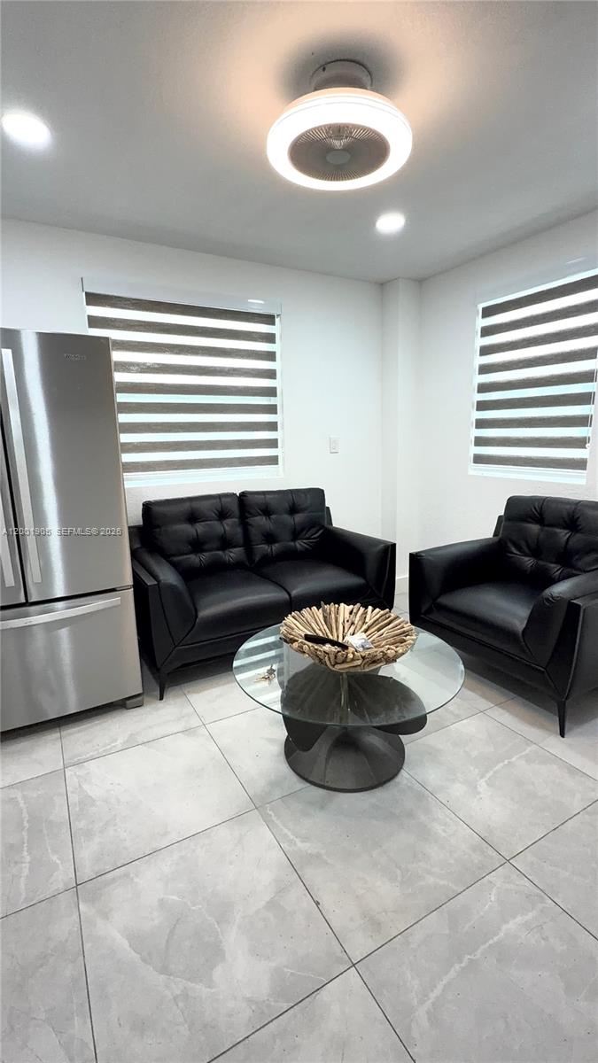 A living area features a black sofa and armchair, a glass coffee table, and tile flooring — 20 Eagle Dr, Key Largo FL 33037, KEY LARGO, FL