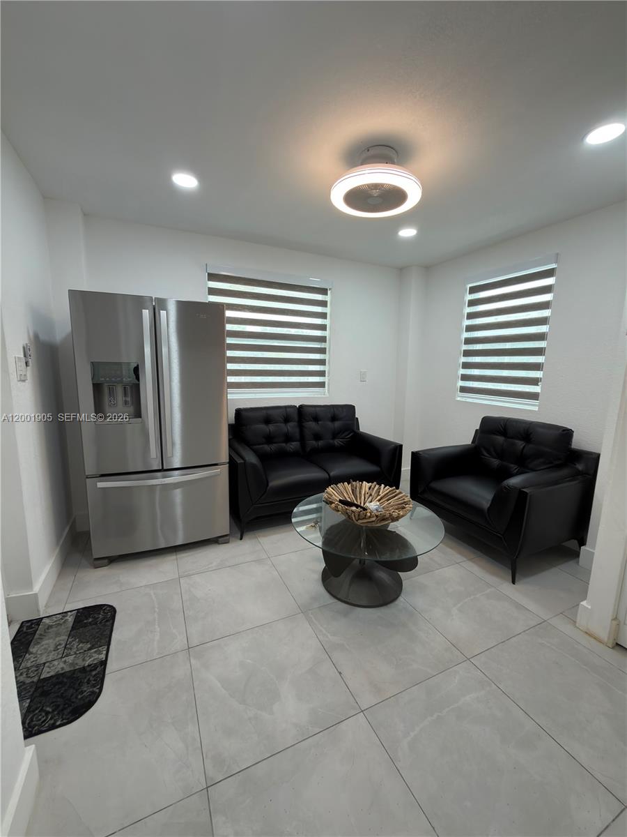 A small living area features a stainless steel refrigerator, black leather seating, and tiled floors — 20 Eagle Dr, Key Largo FL 33037, KEY LARGO, FL