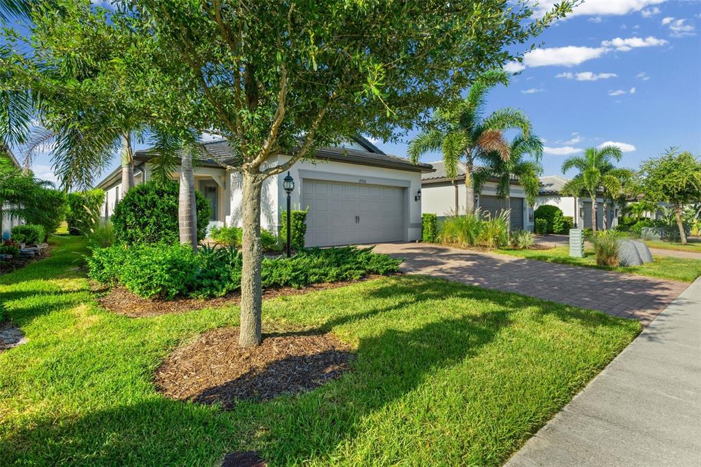 A single-story house with a paved driveway, a two-car garage, and palm trees in front — 17726 NORTHWOOD PLACE, BRADENTON, FL