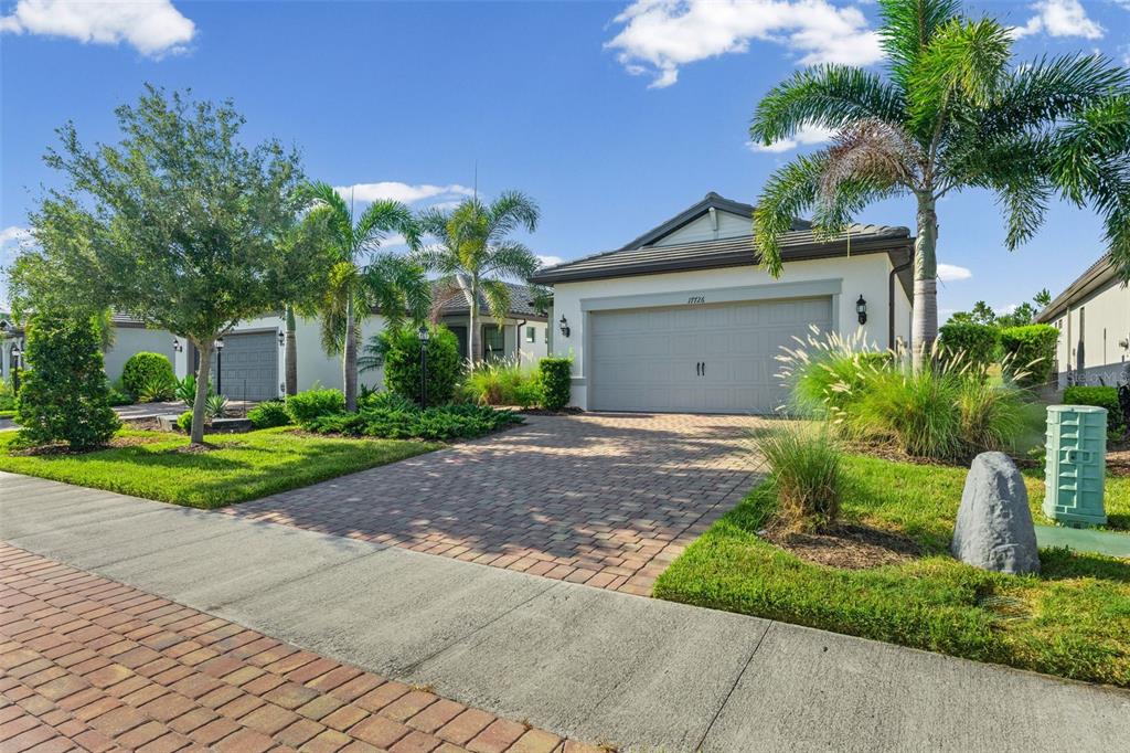 A single-story house with a paved driveway, a two-car garage, and palm trees in front — 17726 NORTHWOOD PLACE, BRADENTON, FL